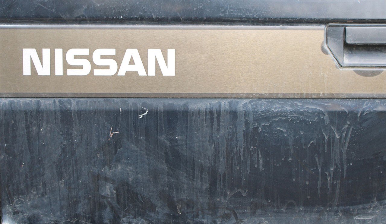 Nissan tailgate before detailing, covered in dirt and grime